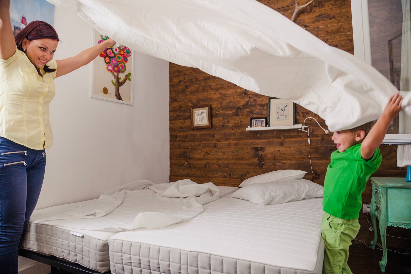 woman-with-kid-playing-with-sheet_23-2147663919